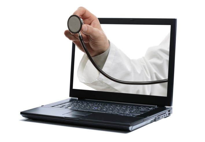 Doctors hand holding a stethoscope through a laptop screen towards a patient