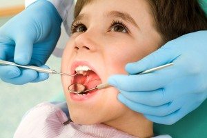 Close-up of little boy opening his mouth wide during inspection of oral cavity
